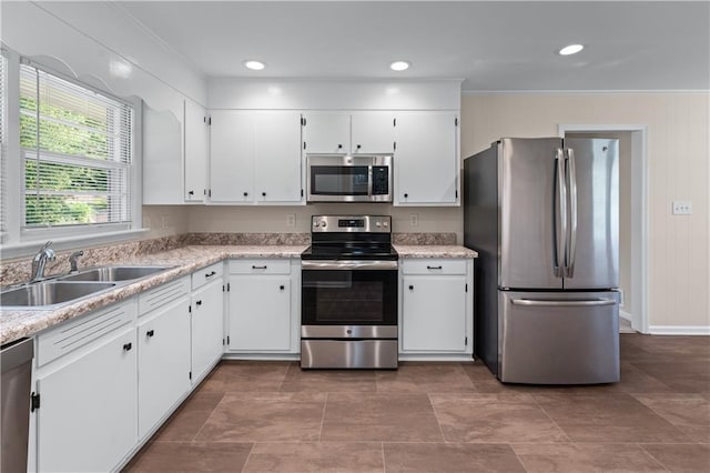 156 Ridgeway St, Winder, GA 30680 - kitchen with appliances with stainless steel finishes, a sink, white cabinets, light countertops, and crown molding