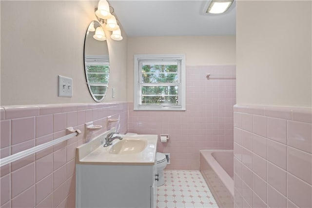 156 Ridgeway St, Winder, GA 30680 - bathroom featuring tile walls, vanity, a bath, toilet, and wainscoting