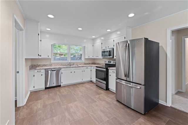 156 Ridgeway St, Winder, GA 30680 - kitchen with appliances with stainless steel finishes, a sink, white cabinets, light stone counters, and baseboards