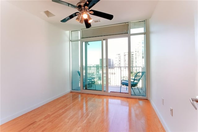 unfurnished room with ceiling fan, light hardwood / wood-style flooring, and expansive windows