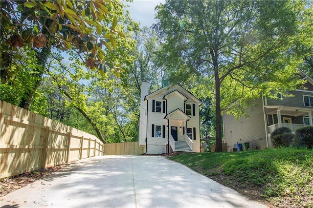 view of front of property with a chimney and fence