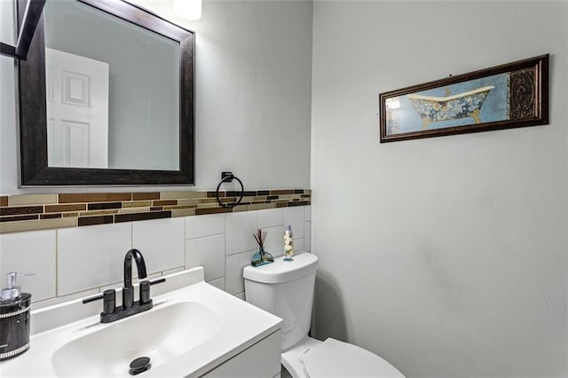 bathroom featuring vanity, toilet, and tile walls