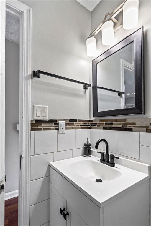 bathroom featuring vanity and tile walls