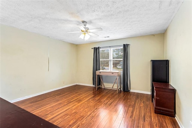 empty room featuring baseboards, a textured ceiling, hardwood / wood-style flooring, and a ceiling fan