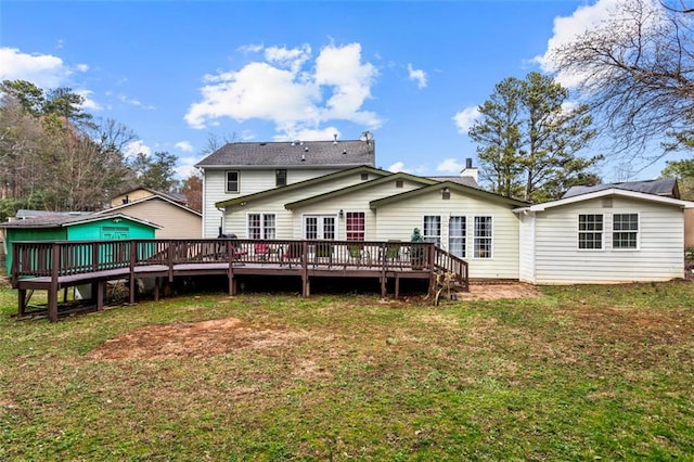 rear view of property featuring a yard and a deck