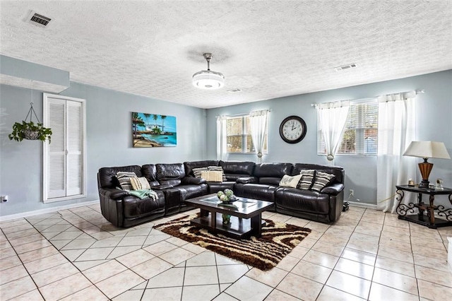 living room featuring light tile patterned floors, plenty of natural light, and visible vents