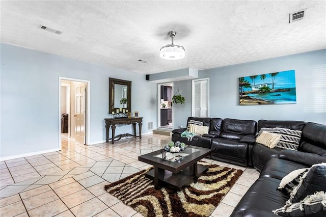 living room featuring light tile patterned floors, visible vents, and a textured ceiling