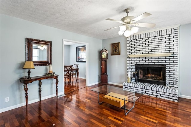 living room with a textured ceiling, baseboards, and wood finished floors