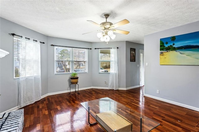 unfurnished room featuring a textured ceiling, hardwood / wood-style floors, a ceiling fan, and baseboards