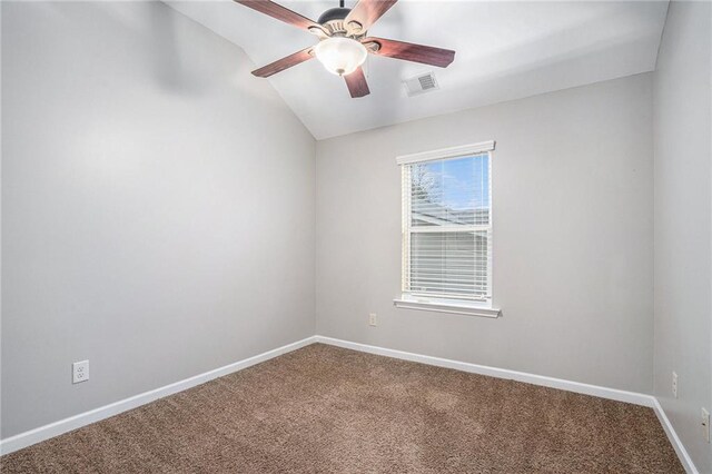 carpeted spare room featuring ceiling fan and vaulted ceiling