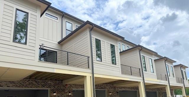 001 White St Unit 1, Marietta, GA 30060 - view of side of property featuring a balcony, an attached garage, board and batten siding, and brick siding