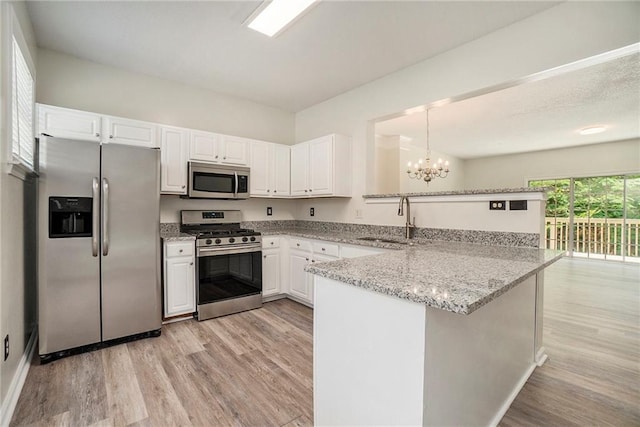 234 Riverstone Commons Cir, Canton, GA 30114 - kitchen featuring stainless steel appliances, a peninsula, light wood-style floors, and a chandelier