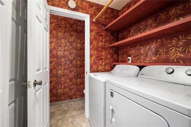 clothes washing area with laundry area, light tile patterned flooring, washer and dryer, baseboards, and wallpapered walls