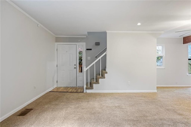 carpeted entrance foyer featuring visible vents, crown molding, stairs, baseboards, and recessed lighting