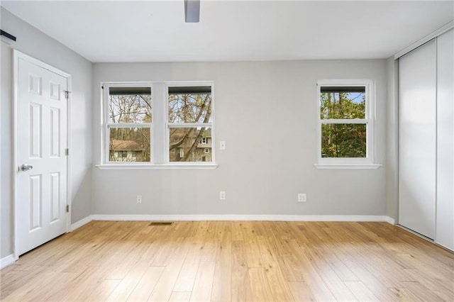 unfurnished bedroom featuring light wood-style floors, baseboards, ceiling fan, and visible vents