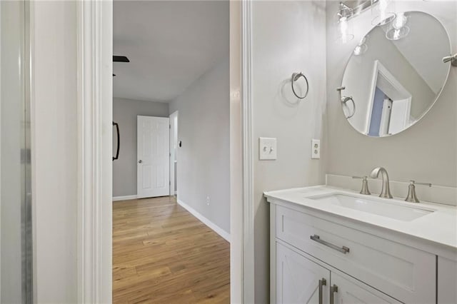 bathroom featuring baseboards, vanity, and wood finished floors