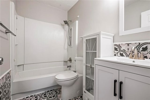 bathroom with vanity, a textured ceiling, shower / bathtub combination, and toilet