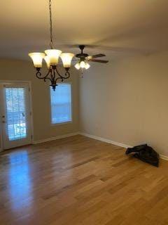 unfurnished room with wood-type flooring and ceiling fan with notable chandelier