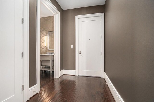 foyer with dark wood-type flooring and baseboards