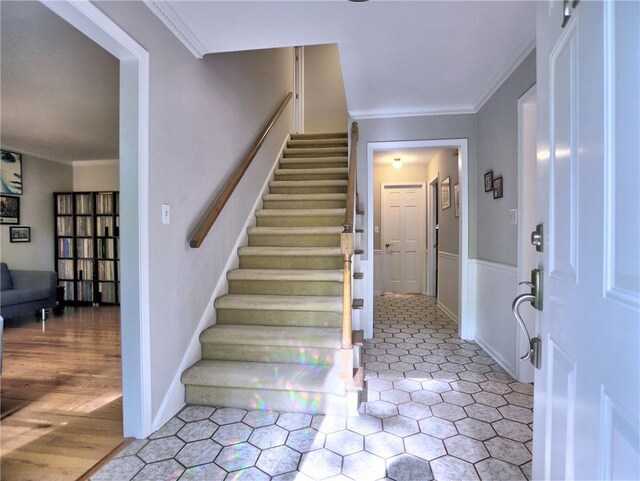 foyer entrance with ornamental molding and stairway