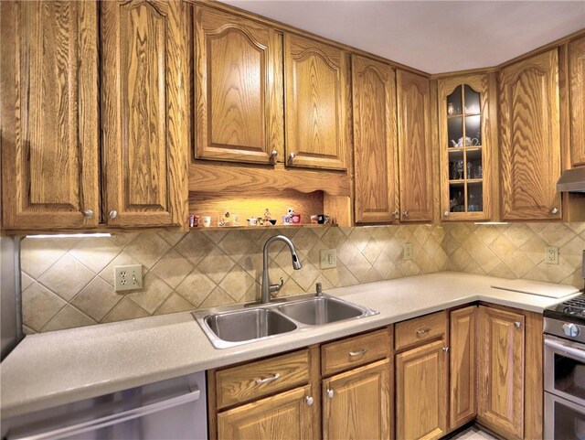 kitchen with a sink, appliances with stainless steel finishes, and brown cabinets