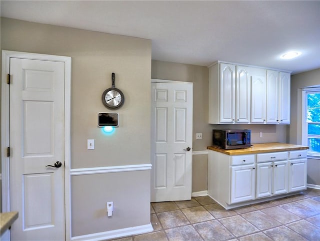 1257 Independence Way, Marietta, GA 30062 - kitchen with stainless steel microwave, baseboards, white cabinets, and wood counters