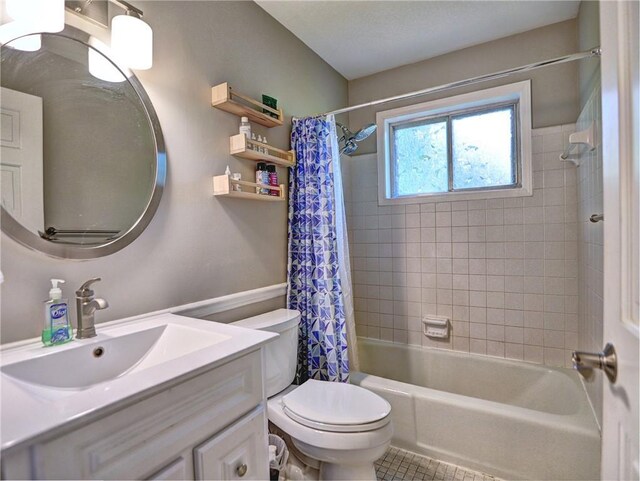 bathroom featuring vanity, tile patterned flooring, shower / bath combo with shower curtain, and toilet