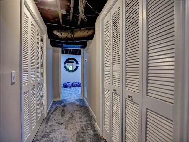 corridor with baseboards and carpet flooring