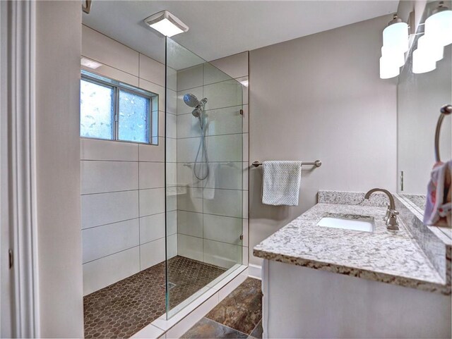 full bath featuring a walk in shower, a chandelier, and vanity