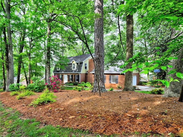 colonial inspired home with a garage and brick siding
