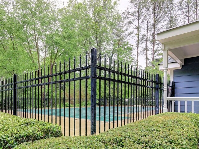 view of gate featuring fence and a fenced in pool