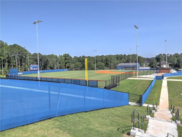 view of sport court with a yard and a view of trees