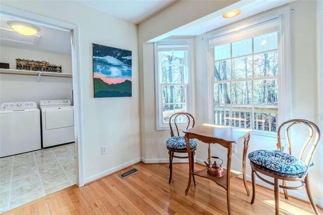 sitting room with independent washer and dryer and light wood-type flooring