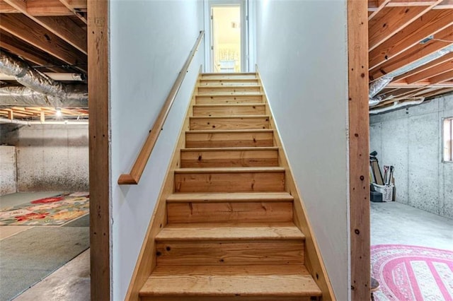 stairs featuring concrete flooring