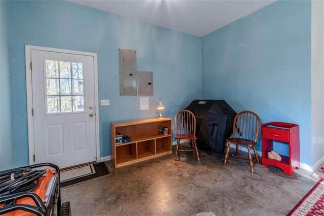 living area featuring electric panel and concrete flooring