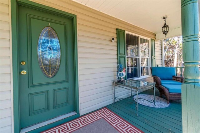 view of exterior entry featuring covered porch