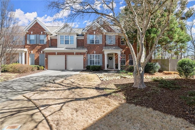 view of front of home with brick siding, fence, driveway, and an attached garage