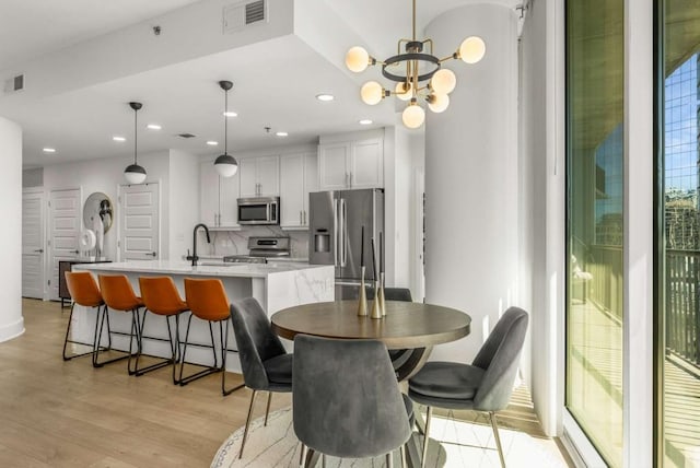 1080 Peachtree St NE Unit 1909, Atlanta, GA 30309 - dining area with recessed lighting, visible vents, an inviting chandelier, and light wood-style floors