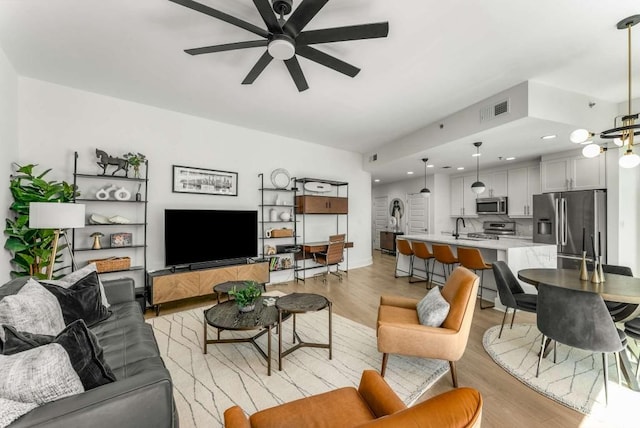 1080 Peachtree St NE Unit 1909, Atlanta, GA 30309 - living room featuring light wood-style floors, ceiling fan with notable chandelier, and visible vents
