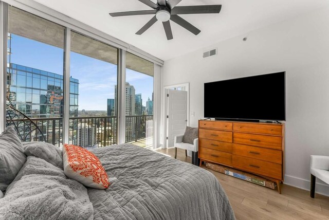 1080 Peachtree St NE Unit 1909, Atlanta, GA 30309 - bedroom featuring visible vents, baseboards, expansive windows, wood finished floors, and access to outside