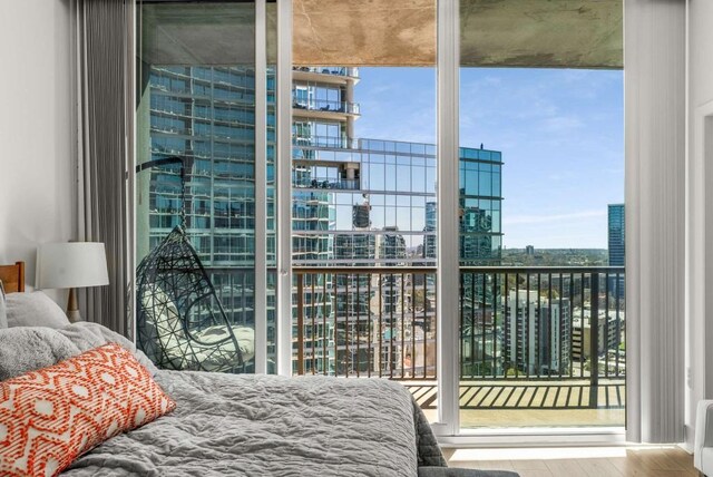 1080 Peachtree St NE Unit 1909, Atlanta, GA 30309 - bedroom featuring access to exterior, expansive windows, a view of city, and wood finished floors