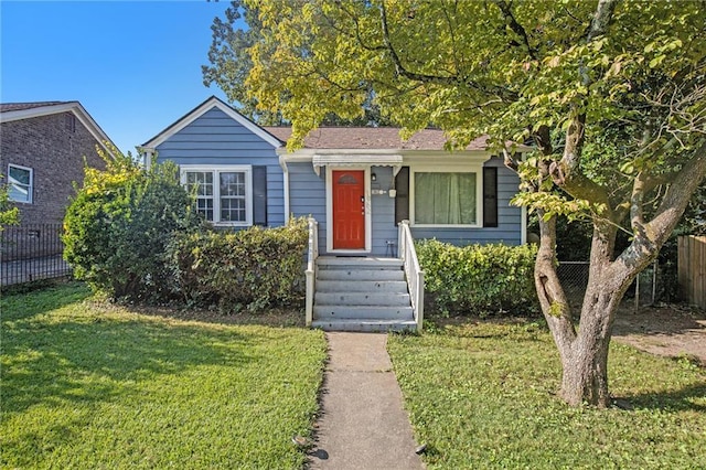 view of front of home with fence and a front lawn