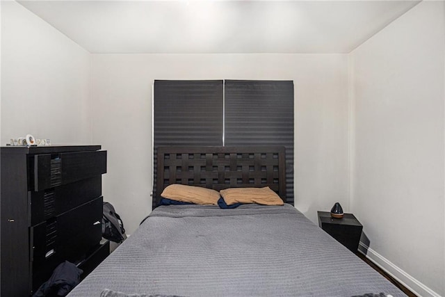 bedroom with wood finished floors and baseboards