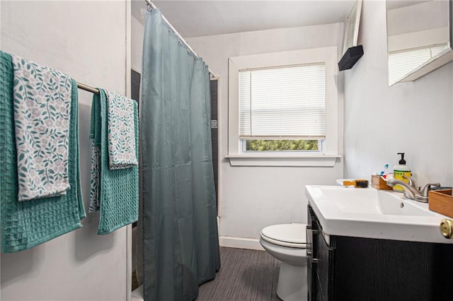 full bath with curtained shower, vanity, toilet, and baseboards