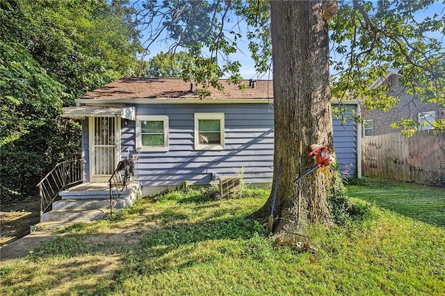 bungalow featuring a front lawn and fence