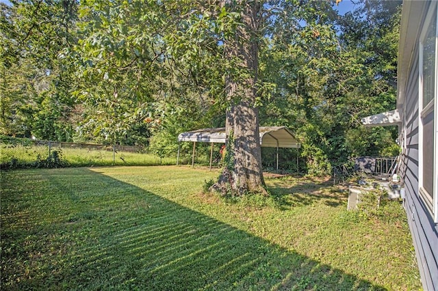 view of yard with fence and a detached carport