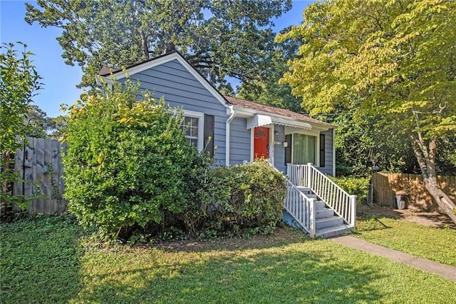 bungalow with fence and a front yard