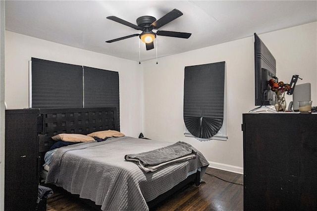 bedroom with baseboards, dark wood finished floors, and a ceiling fan