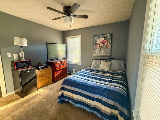 bedroom with carpet floors, a textured ceiling, and ceiling fan