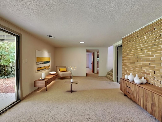 3861 Foxford Dr, Atlanta, GA 30340 - living area with stairs, light carpet, a textured ceiling, and brick wall